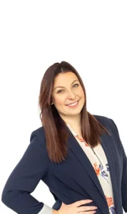 A woman in a blue jacket smiling for the camera.